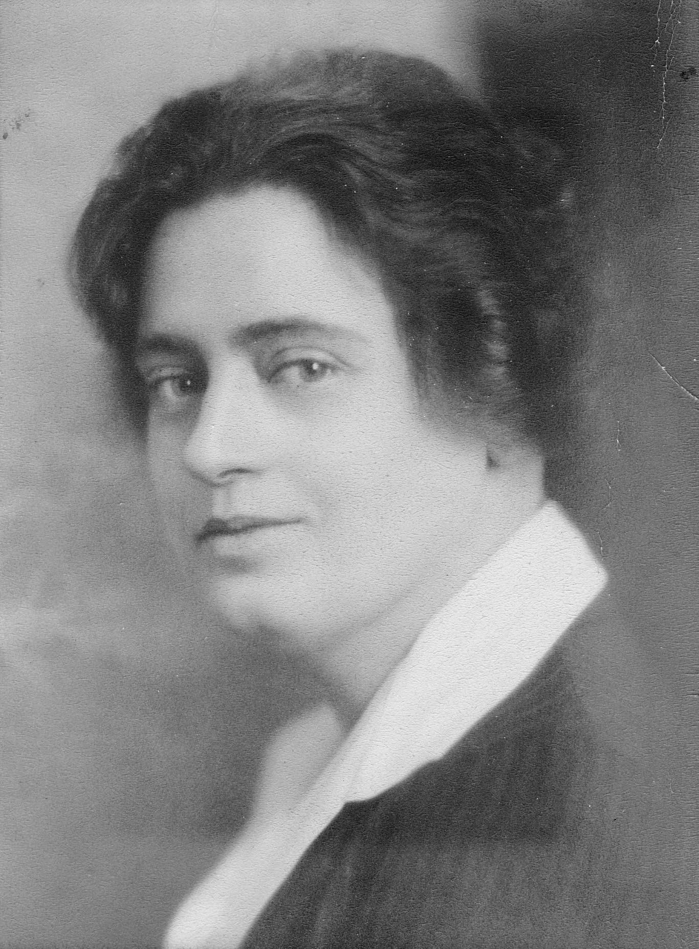 A black and white image of Lorena Hickok in ¾ profile. Her brown hair is pulled back, and she wears a white-collared blouse with a pinstriped blazer